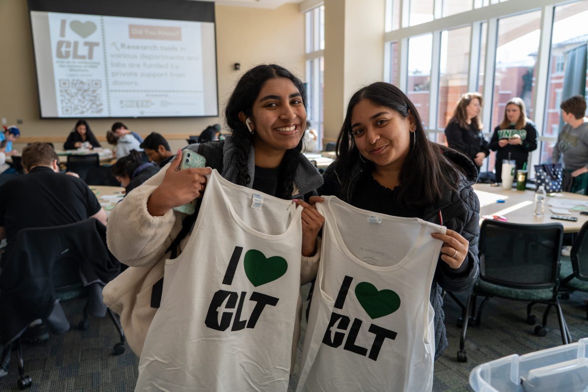 Students holding I heart CLT tanks
